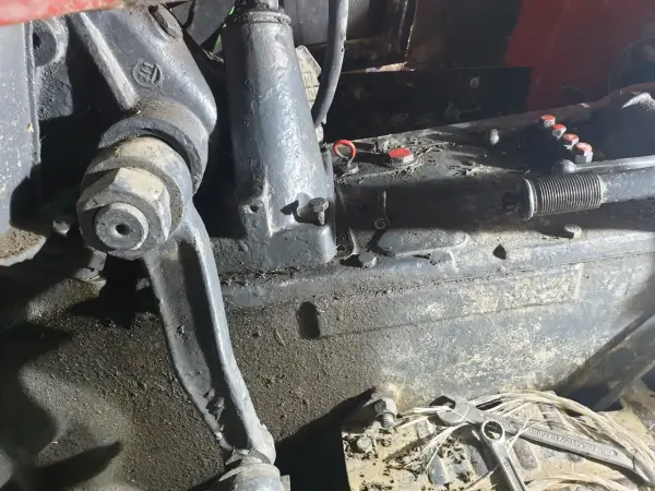 Elementy mechaniczne ciągnika Ursus C-360 podczas remontu skrzyni biegów. Widać ślady oleju i narzędzia.