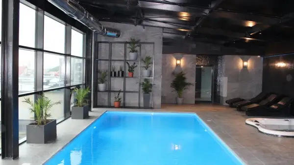 Nowoczesny hotel spa Białystok z basenem, jacuzzi i leżakami. Duże okna z widokiem na miasto.