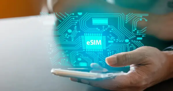 Dłoń trzyma smartfon, nad którym unosi się cyfrowy obwód z napisem eSIM. To przyszłość łączności, esim bez abonamentu.