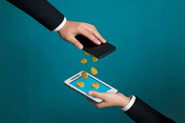 Przelew pieniędzy między telefonami. Złote monety spadają z jednego smartfona na drugi, symbolizując pismo o zwrot refinansowania.