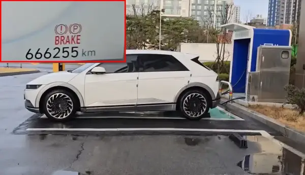 Biały Hyundai Ioniq 5 z przebiegiem 666255 km ładuje się przy stacji ładowania.