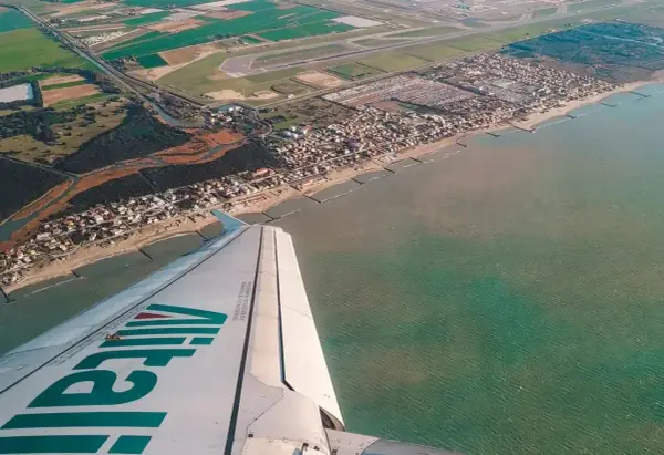 Widok z samolotu Alitalia na wybrzeże Włoch. Zastanawiasz się, ile się leci do Włoch?