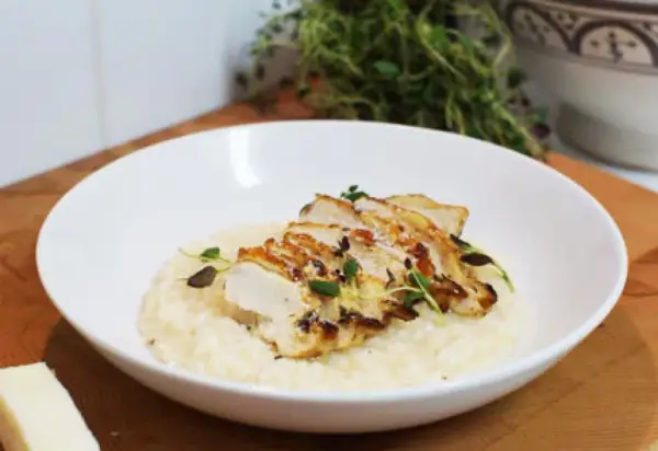 En krämig risotto med kyckling, toppad med färska örter och en bit parmesan. En perfekt risotto med kyckling för en härlig middag.