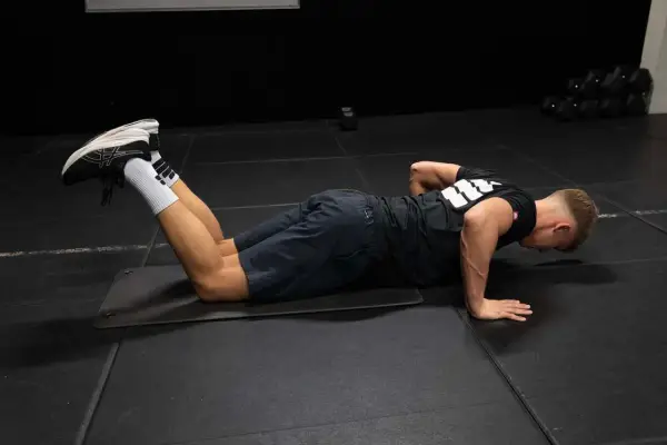 Man utför armhävningar på knä som en del av rehab axel.