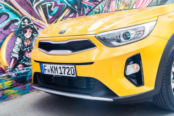 Żółty, stonic kia z pirackim graffiti w tle.