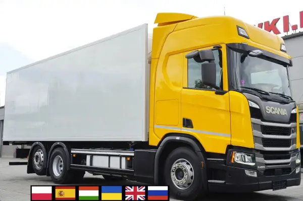 Żółta Scania R z białą naczepą chłodnią, gotowa do dalekich podróży.