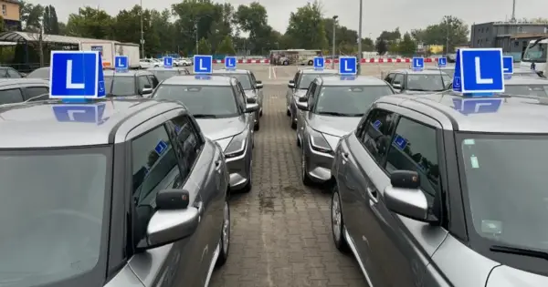 Rząd srebrnych aut z niebieskimi literami "L" na dachach. Czekają na kursantów, którzy zdali teorię i chcą jak najszybciej zdać praktykę.