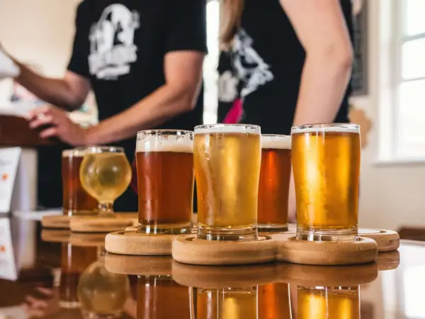 Degustacja różnych rodzajów niemieckiego piwa. Jasne i ciemne trunki w szklankach na drewnianych podstawkach.