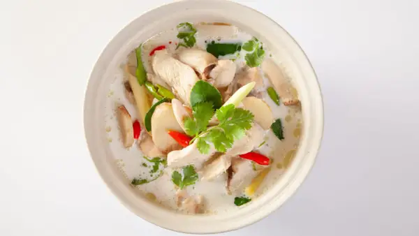 En skål med krämig tom kha gai med kyckling, svamp, chili och koriander.