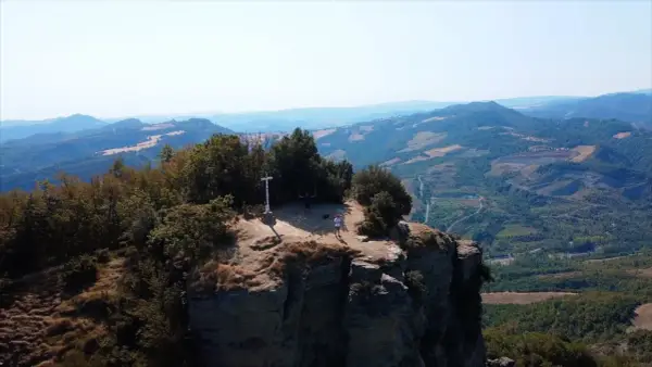 Due escursionisti celebrano la vetta raggiunta sul crinale, un momento clou del cammino della Via degli Dei in 5 giorni.