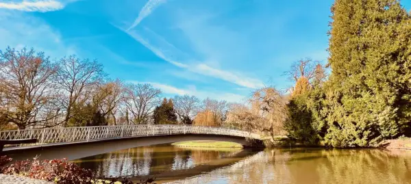 Eine Brücke über einen Teich im Bergpark Wilhelmshöhe. Hier kann man in Kassel spazieren gehen und die Natur genießen.