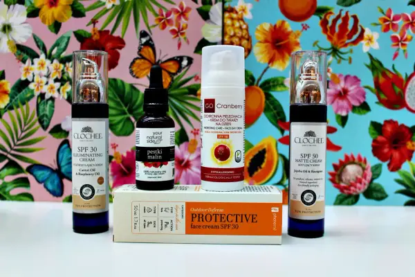 Kremy z filtrem SPF 30 i SPF 50, olejek z pestek malin i krem ochronny z dwutlenkiem tytanu na tle tropikalnych kwiatów i motyli.