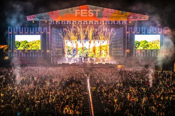 Ogromny tłum na fest festiwalu, scena rozświetlona fajerwerkami i ekranami.