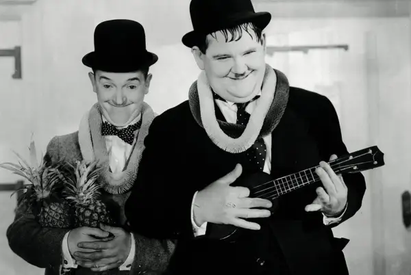 Laurel et Hardy, l'un tenant des ananas, l'autre jouant d'un ukulélé, évoquent l'origine hawaïenne de cet instrument.