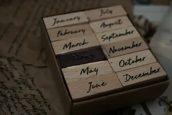Drewniane stemple z nazwami miesięcy. Widać stempel z napisem "June" (czerwiec), obok "May" (maj) i "July" (lipiec).