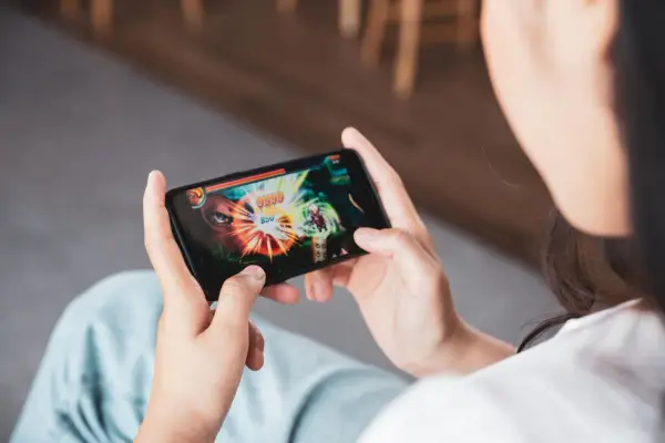 Osoba gra w ekscytujące gry multiplayer na telefonie, walcząc z potężnym przeciwnikiem.