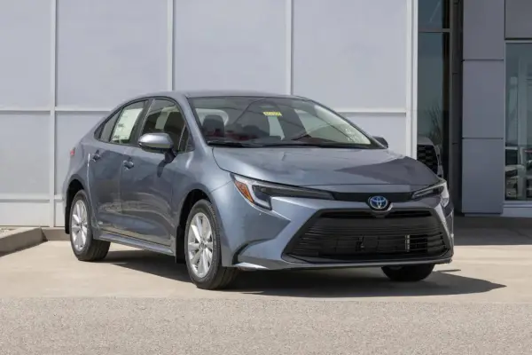 Grigio Toyota Corolla, un'auto a metano ecologica, parcheggiata davanti a un edificio moderno.