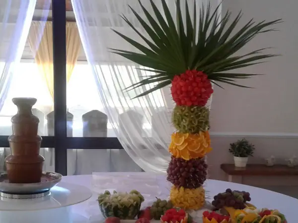 Kolorowa wieża z owoców: maliny, kiwi, pomarańcze, winogrona, ananas. Idealne jakie owoce do fontanny czekoladowej.