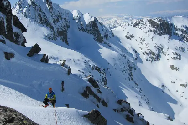 Alpinista en pendiente nevada, listo para ascender. Una escena perfecta para cursos de alpinismo.