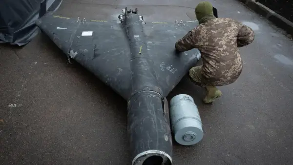 Ein Soldat inspiziert eine Drohne in Rumänien. Daneben liegt eine Munitionshülse.