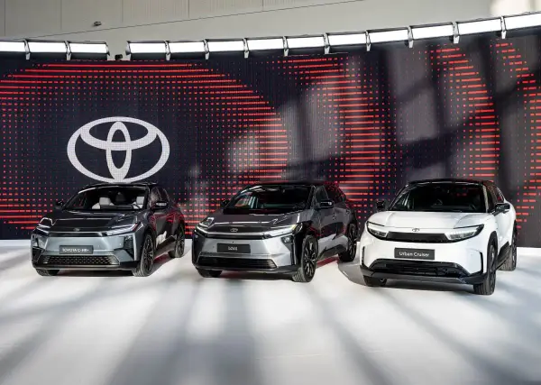Trzy nowoczesne japońskie marki samochodów: Toyota C-HR+, bZ4X i Urban Cruiser, prezentowane na tle logo Toyoty.