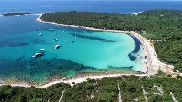 Turkusowa zatoka z łodziami, jedna z najpiękniejszych plaż w Chorwacji.