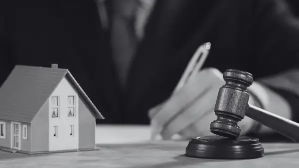 Model domu i młotek sędziowski symbolizują sprawę o reklamację z tytułu rękojmi.