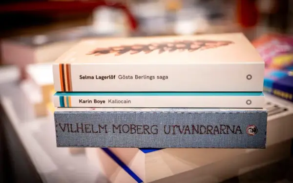 En stapel böcker med Selma Lagerlöf, Karin Boye och Vilhelm Moberg. Ur ett annat person perspektiv ser man titlarna tydligt.