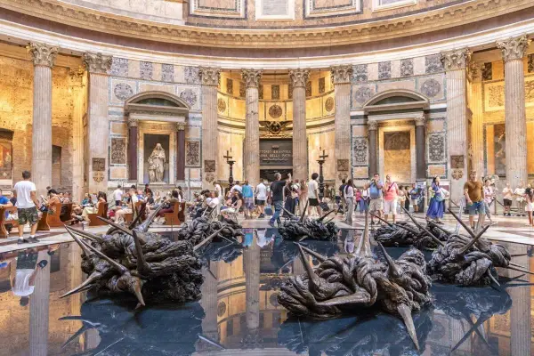 Intérieur du Panthéon de Rome, avec des sculptures modernes sur l'eau reflétant l'architecture antique.