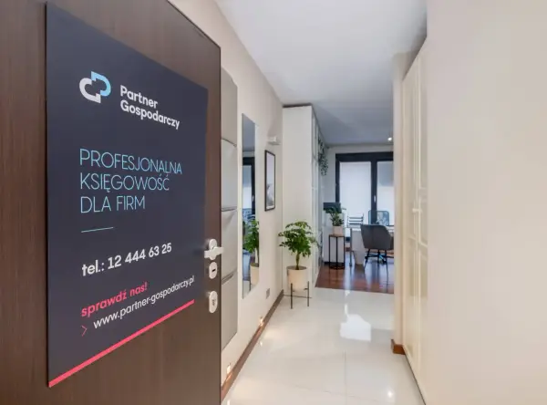Tabliczka na drzwiach z logo "Partner Gospodarczy" i hasłem "Profesjonalna księgowość dla firm".