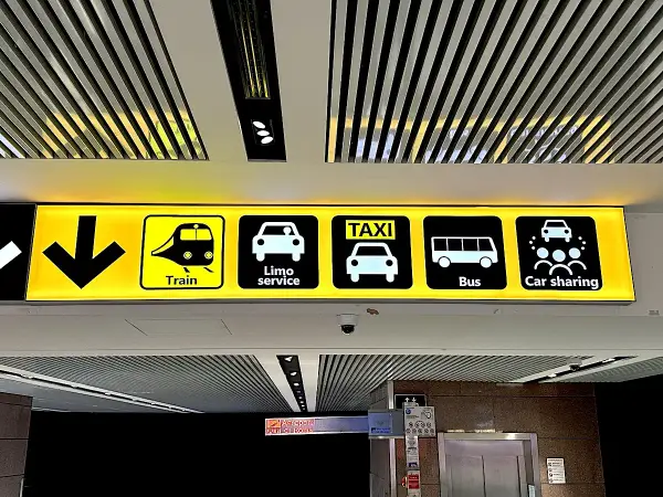 Znaki na lotnisku Fiumicino w Rzymie: pociąg, limuzyna, taxi, autobus, car sharing.