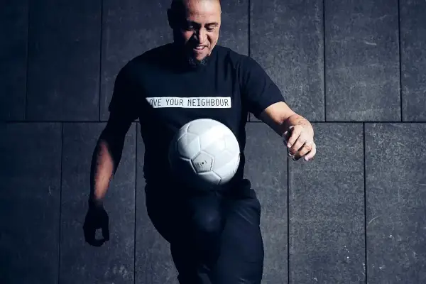 Roberto Carlos żyje i wciąż czaruje piłką! Legenda futbolu w czarnej koszulce z przesłaniem "LOVE YOUR NEIGHBOUR" bawi się białym futbolem.