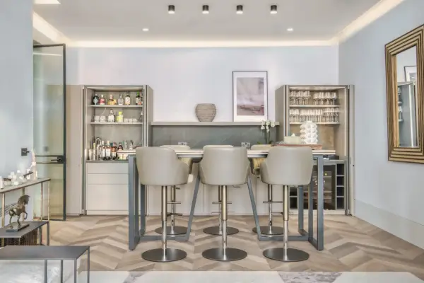 Modern bar area with sleek bar stools. The question of whether bar stools should match dining chairs is answered by this elegant setup.