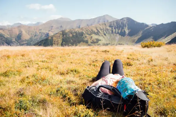 Odpoczynek w jesiennych Tatrach. Po wędrówce, gdzie w Tatry, można się zrelaksować na trawie, podziwiając góry.
