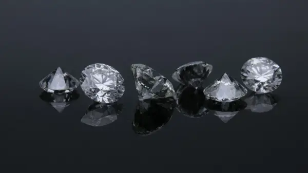 Siedem błyszczących diamentów na czarnym tle. Co oznacza diament na sympatii? Symbol trwałości i piękna, jak te kamienie.