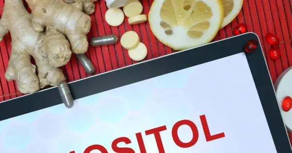 Tablet z napisem "INOZYTOL CO TO". Obok imbir, plasterki cytryny, kapsułki i tabletki.