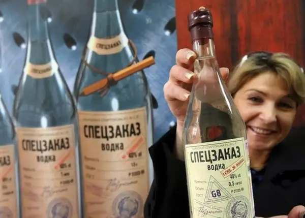 Kobieta trzyma butelkę wódki "Speczakaz", która opowiada historię, skąd pochodzi wódka.