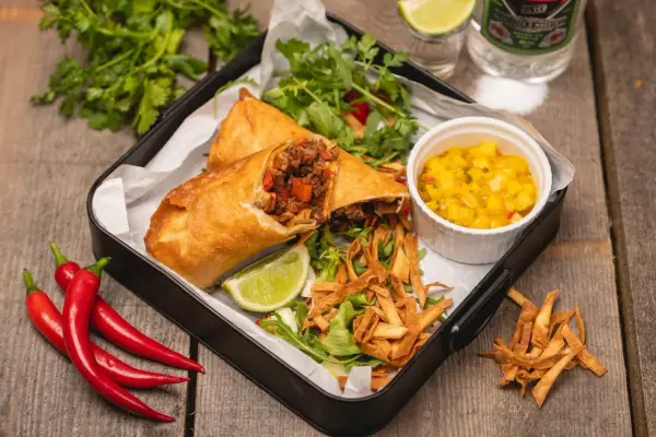 Chrupiące rolki z nadzieniem mięsnym i warzywnym, podane z salsą mango, sałatką i limonką. Prawdziwy smak tex mex!