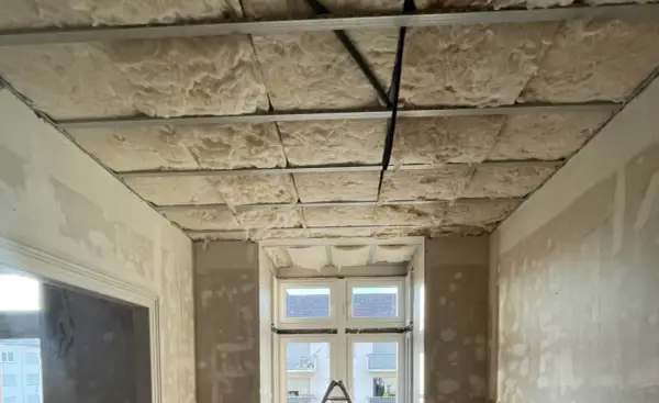 Isolation de plafond en laine de roche, réduisant le bruit de 3 décibels. Exemple de chantier.