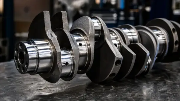 Precyzyjna budowa wału korbowego, kluczowego elementu silnika, ukazana na metalicznej powierzchni.