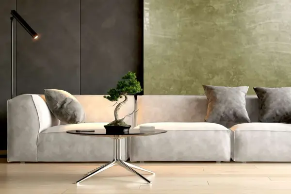 Nowoczesny salon z sofą, stolikiem i bonsai. Ściana za sofą pokryta jest efektowną **glinką wenecką** w odcieniach zieleni i grafitu.