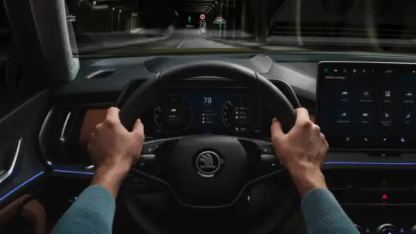 Fahrer hält Lenkrad, digitale Anzeige zeigt 78 km/h. Der Tempomat funktioniert nicht, die Fahrt geht durch einen dunklen Tunnel.