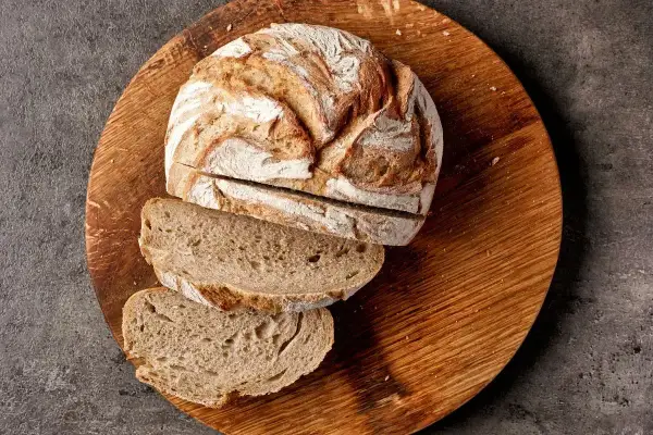 Chleb żytni na zakwasie, pokrojony na desce, to dobry wybór, jeśli szukasz pieczywa, jakie pieczywo ma najmniej kalorii.