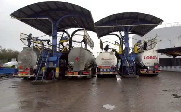 Camions citernes en cours de chargement sous des auvents. Le chauffage fioul prix est une préoccupation majeure pour les ménages.