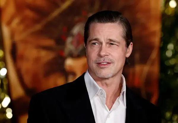 Brad Pitt w czarnym garniturze i białej koszuli, z lekkim zarostem. Wygląda jakby zastanawiał się, kiedy urodził się Brad Pitt.