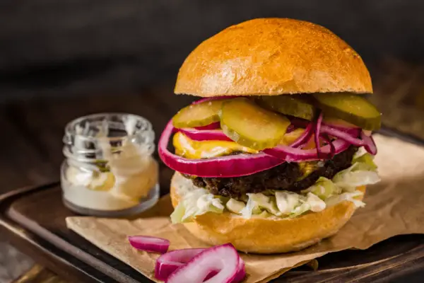 Pyszny burger z soczystą wołowiną, chrupiącą sałatą, piklami, czerwoną cebulą i majonezem. Idealny na prawdziwe burgery przepis.