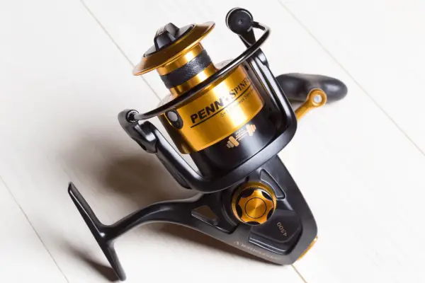 Czarny kołowrotek spinningowy Penn Spinfisher V 4500 ze złotymi akcentami, idealny do plecionki.