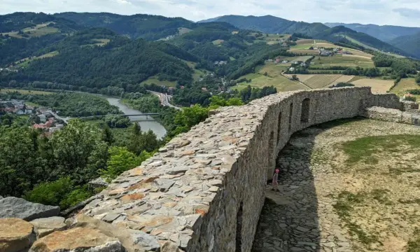 Kamienne mury zamku w Rytrze, z których roztacza się widok na dolinę Dunajca i okoliczne wzgórza. To wspaniałe **rytro atrakcje** dla miłośników historii i przyrody.