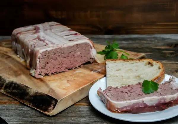 Pate zawinięte w boczek, pokrojone na talerzyku z chlebem. Pyszne pate, idealne na przekąskę.