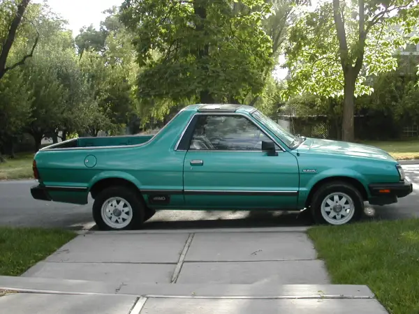 Zielony Subaru Brat z lat 80. stoi na podjeździe, gotowy na przygodę.